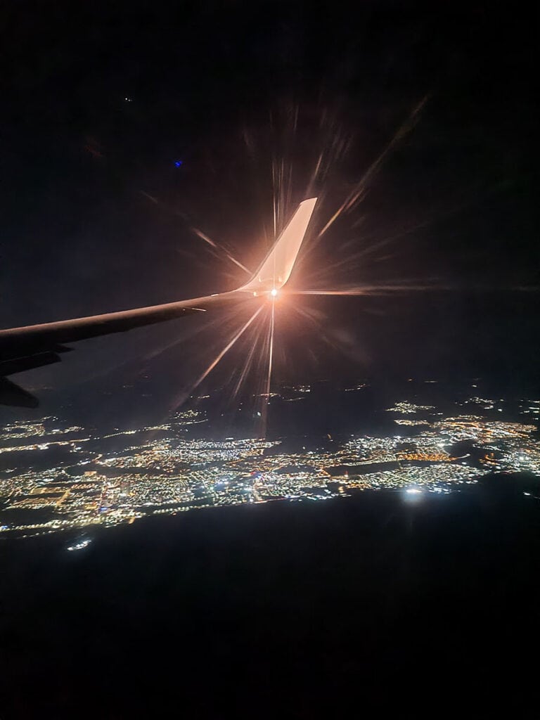 Plane arriving into Queretaro International Airport with the lights of the city lit up below.