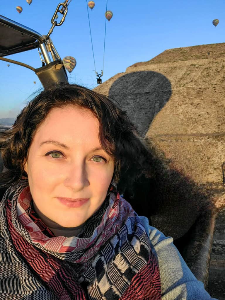 Ashlea riding in a hot air balloon with the pyramids of Teotihuacan in the background.