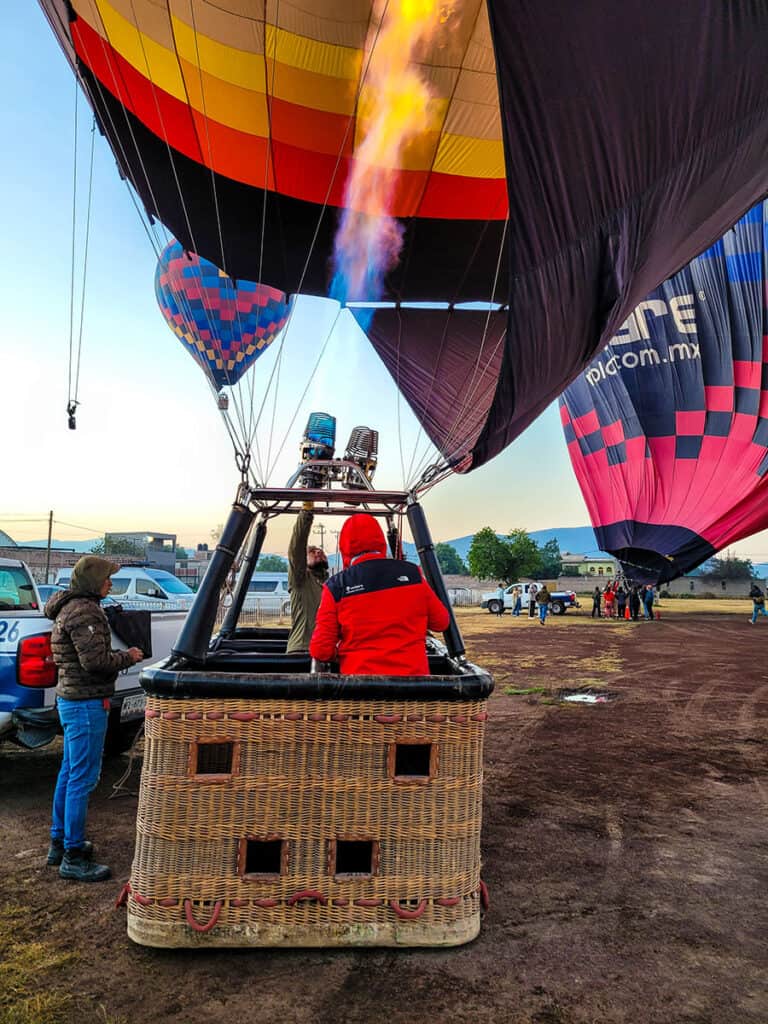 The hot air balloon pilot and crew preparing the balloon and basket for flight.