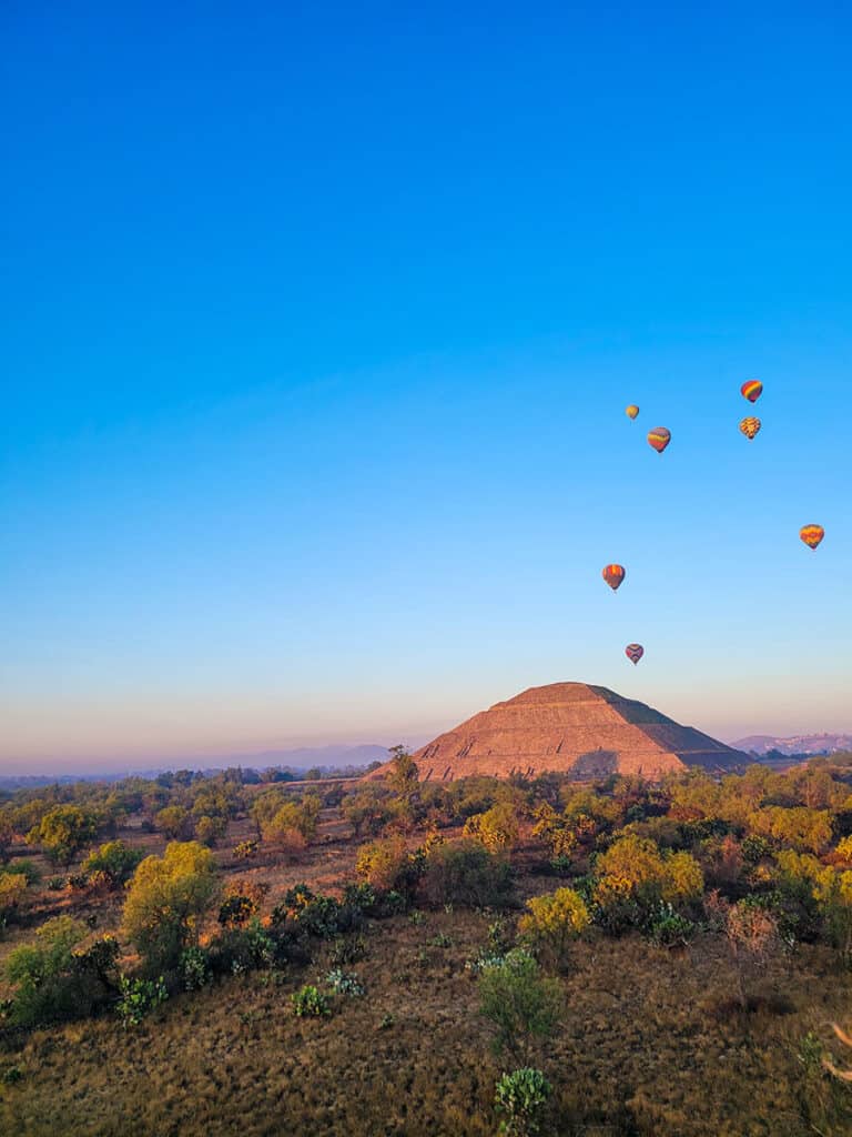 A view of hot air balloons floating over the pyramids of Teotihuacan taken from a hot aair balloon.