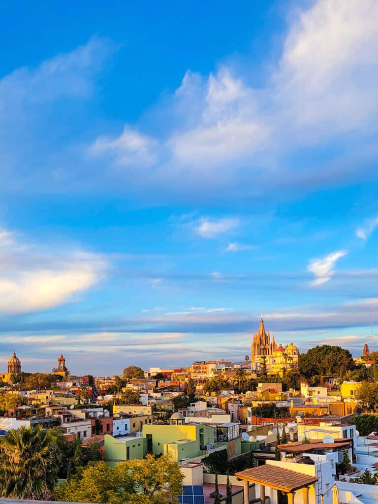 The view over San Miguel de Allende in a golden sunset from the rooftop of Luna at the Rosewood Hotel.