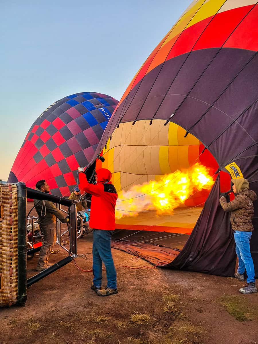 Three men inflating hot air balloons with fire and gas in Mexico.