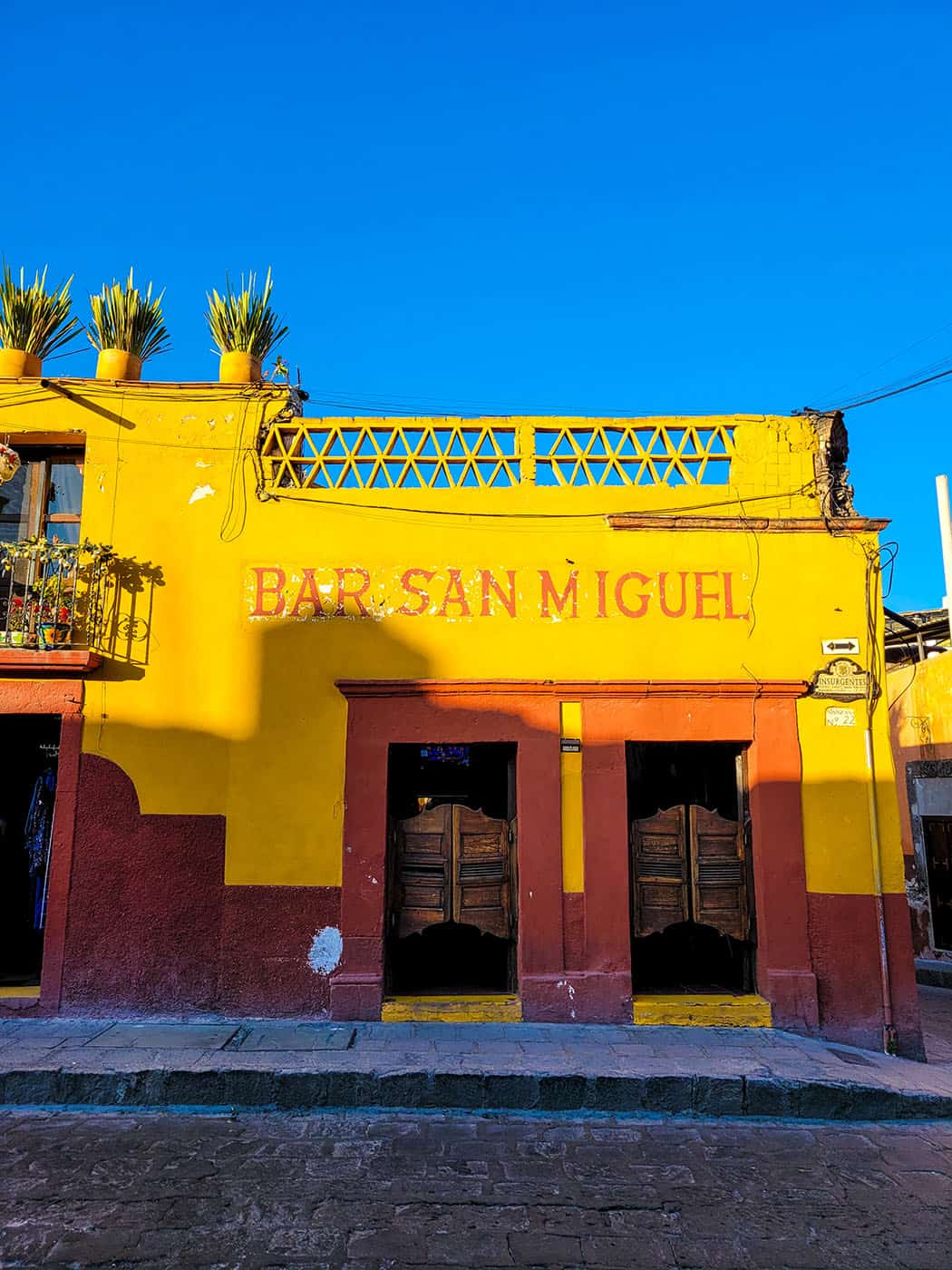 An old fashioned yellow and orange saloon with swinging doors in the centre of San Miguel de Allende.